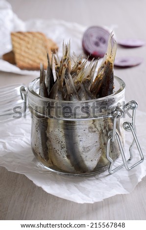 Marinated anchovies in a glass jar tails up