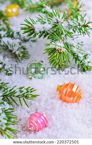 Spruce branches and bright balls lie on the background of white snow