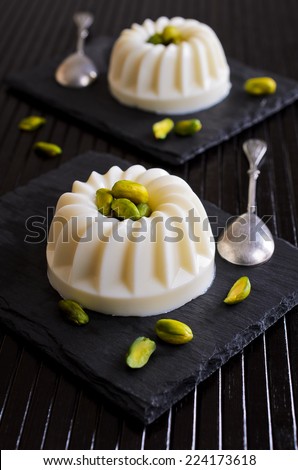 Jelly white with pistachios on a black plate andwas