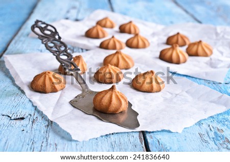 Small cone-shaped cookies brown lies on the blade for cake