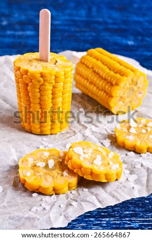 Cut corn on the cob with white crystals on paper