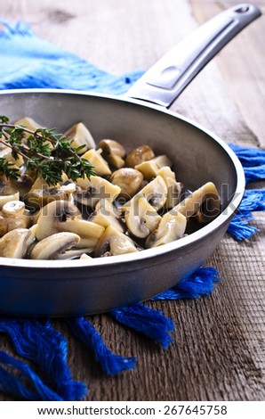Cooked mushrooms with a branch of thyme in the pan