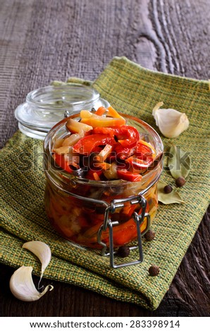 Preserved vegetables in glass jar on wooden background surfaces