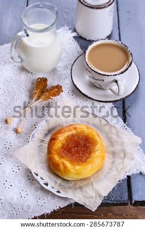 Round sweet bun with jam on a plate covered with paper