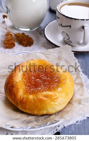 Round sweet bun with jam on a plate covered with paper