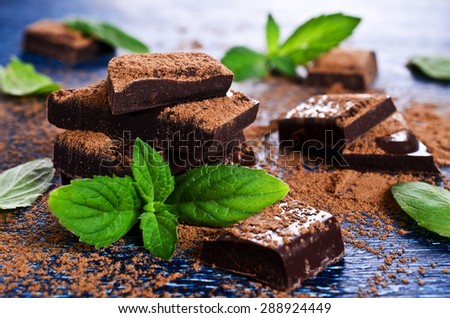 Chocolate, broken into pieces and sprinkled with cocoa powder with mint leaves
