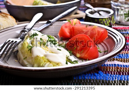 Fried cabbage with white sauce in a ceramic dish