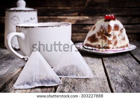 Tea in a disposable package of triangular shape on a wooden surface