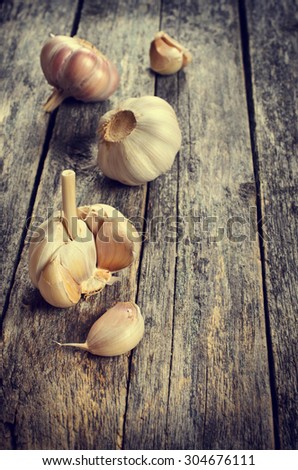 Fresh garlic separated into cloves, on a wooden surface