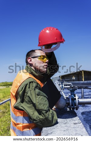 A worker wipes sweat from his face.