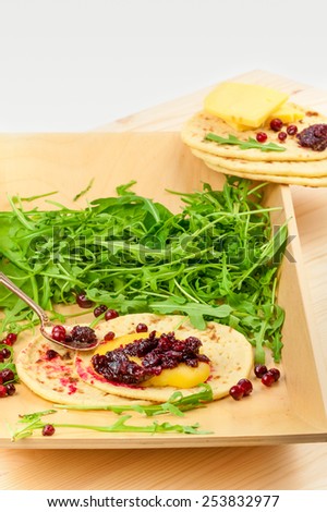 arugula with bread, cheese and cranberry sauce