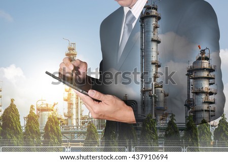 Double exposure of business man hand hold tablet, Energy generating Factory and sunset as technology and energy concept.