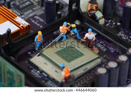 Selective focus of miniature engineer worker to fixed and repair CPU (Central Processing Unit),  mainboard computer as industry concept.
