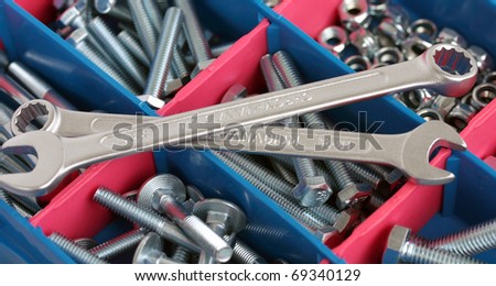 a set of spanners in front of toolbox of bolts and nuts