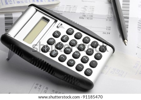 A calculator, pen, and financial statement