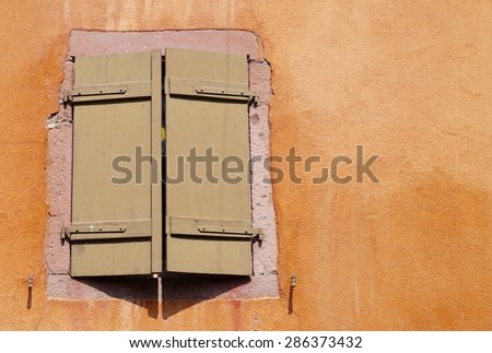 brown folding shutter of an orange house between red bricks