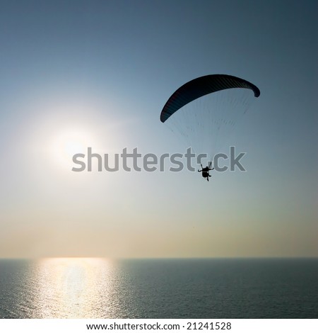 Para-glider over the sea on sunset