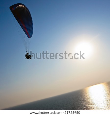 Para-glider over the sea on sunset