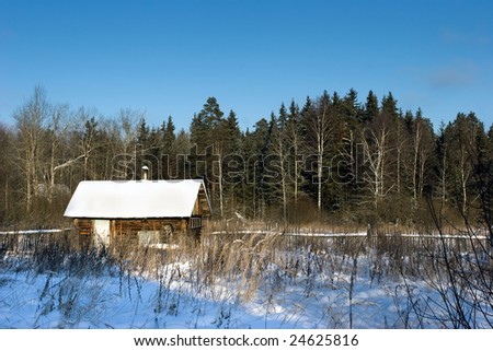 The wooden house on the fringe of the forest in the winter