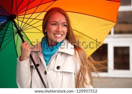 Young woman standing on the street with color umbrella