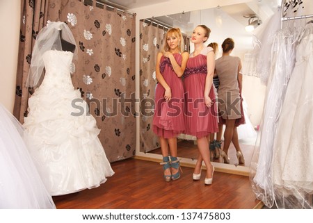 Two girlfriends  -   bridesmaids- having fun -  looking for dresses for wedding