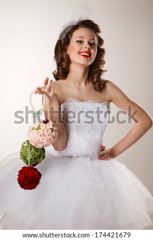 Pin-up bride holds a bouquet.Professional make-up, hair and style