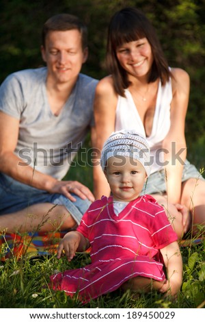Portrait of one year old girl with her happy parents on the background.Selective focus