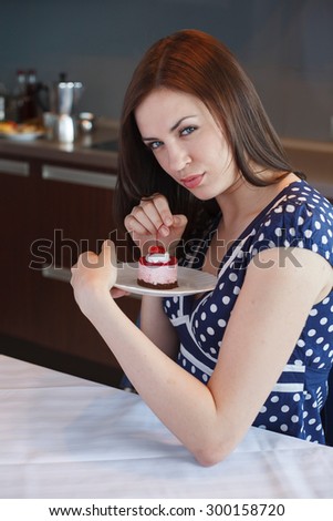 Young greedy woman holds  her cake with face expression \