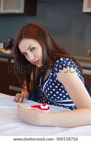 Young greedy woman holds  her cake with face expression \