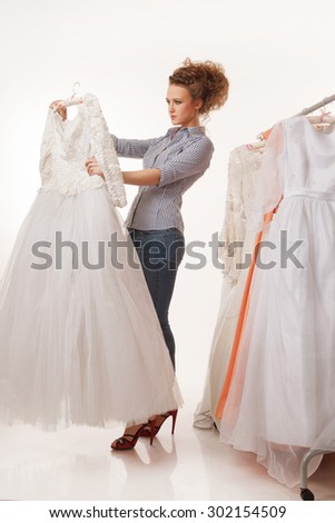 Young beautiful woman is choosing wedding dress