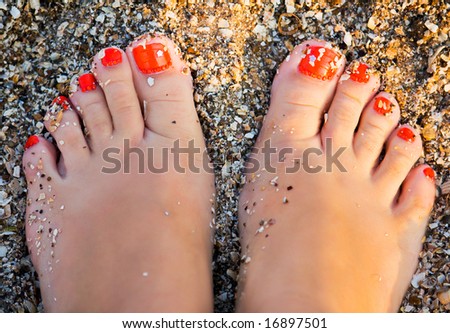 stock photo fingers wet sand at the feet of young girl