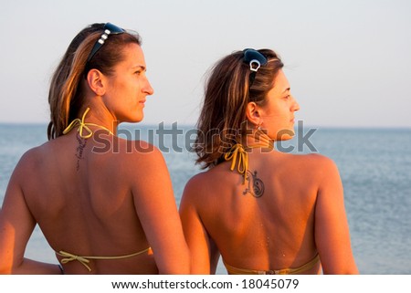 stock photo : portrait of a sisters with tattoos on their backs