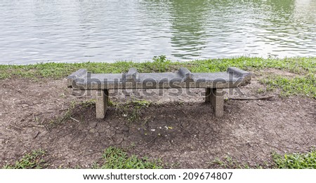 Stone chair beside river in the nature park