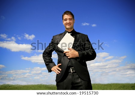 Young man in black suit in the middle of the field.