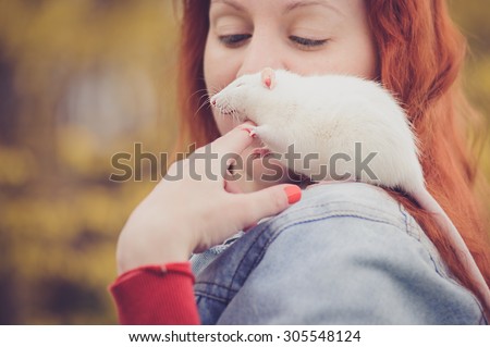 Home rat is sitting on the girl\'s shoulder