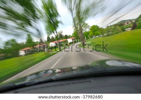 Car is driving on a road direction railway crossing (level crossing). Shot from inside the car with motion blur.
