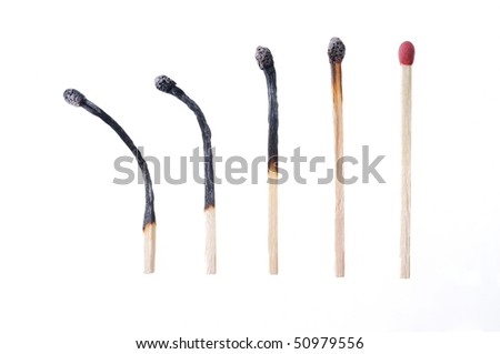 Macro closeup of a group of burned matches, one match unburned, isolated on white background
