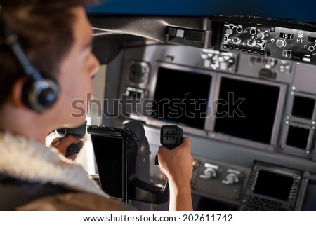 man holding airplane wheel in cockpit