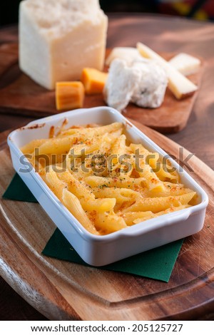 Macaroni cheese in white tray on wooden plate