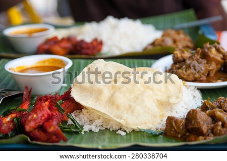 Naan ot chapati - the major food of indian tradition eating  - naan is flat bread over steamed rice on banana leaf plate eat with several type of curry