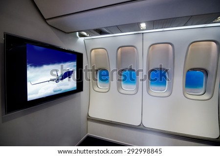 Cabin comfortable flight   passenger plane interior with LCD TV monitor screen display and plane window porthole