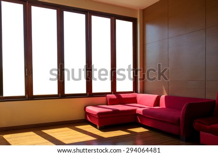 The red sofa over wooden wall  in the living room near panorama wide window with light and shade