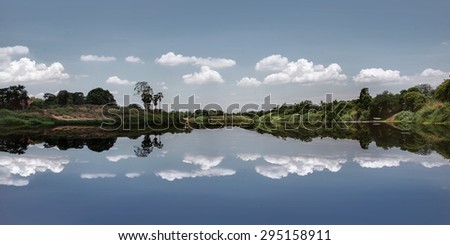 Beautiful of nature - The photo of pastel blue minimal picture with reflection of trees , cloudy sky like a mirror on the water  from countryside of thailand