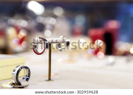Fine luxury platinum ring in jewelry window display of luxury jewelry boutique with glitter background