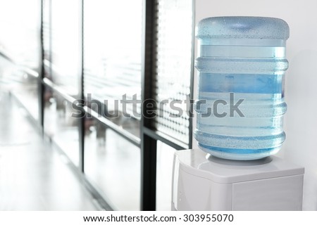 blue water gallon on electric water cooler in office area