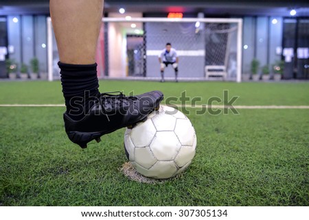 soccer player on penalty kick position with out of focus goalkeeper