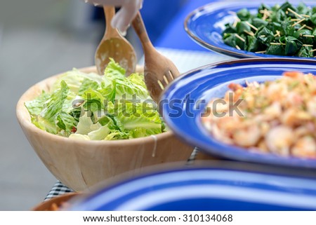 Chef mixing fresh zucchini salad ingredient together