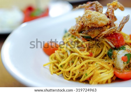 Italian fusion food - pan fried spaghetti with olive oil with crab and topping with deep fried soft shell crab