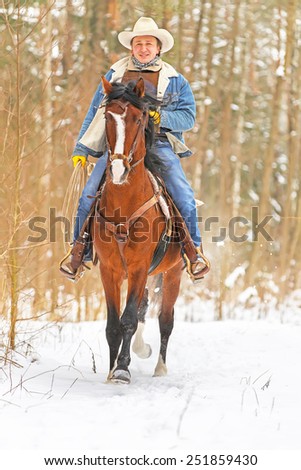 Man riding a horse in a winter forest.