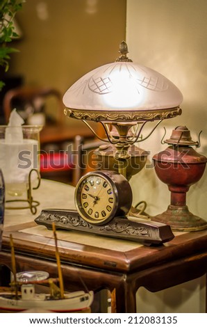 A retro desk clock place under retro desk lamp